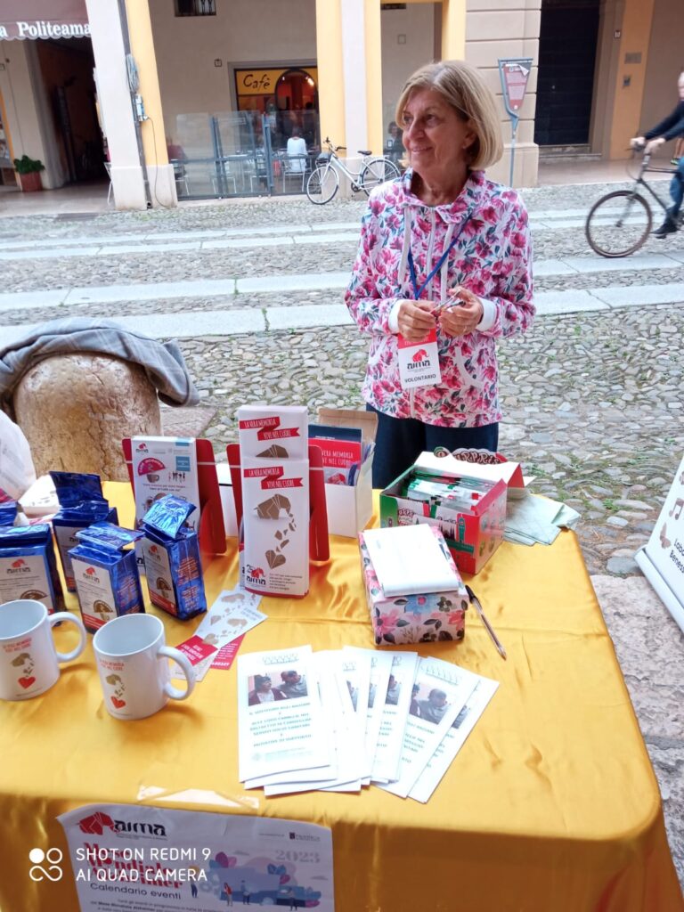 Fotografia dello stand con i volontari di AIMA Reggio Emilia per la campagna #insiemesipuò del Mese Mondiale Alzheimer a Correggio