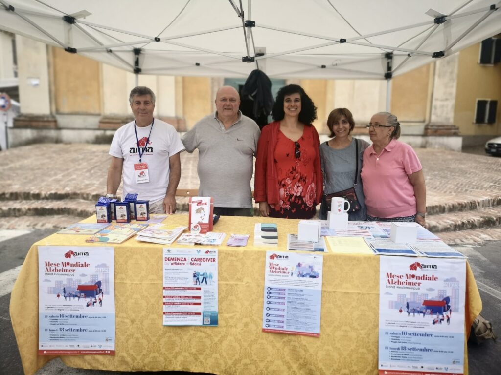 Fotografia dello stand con i volontari di AIMA Reggio Emilia per la campagna #insiemesipuò del Mese Mondiale Alzheimer 2023 a Montecchio Emilia