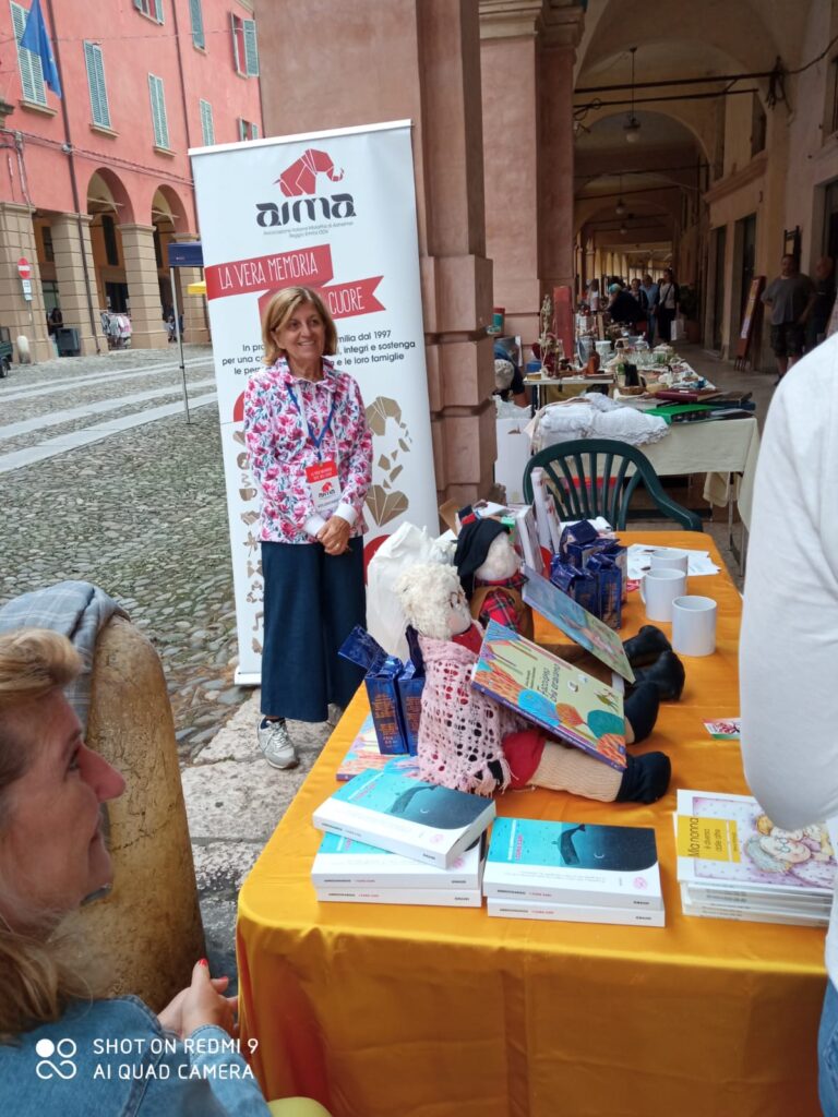 Fotografia dello stand con i volontari di AIMA Reggio Emilia per la campagna #insiemesipuò del Mese Mondiale Alzheimer a Correggio