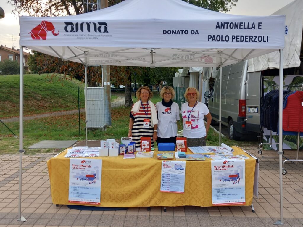 Fotografia dello stand con i volontari di AIMA Reggio Emilia per la campagna #insiemesipuò del Mese Mondiale Alzheimer 2023 a Scandiano