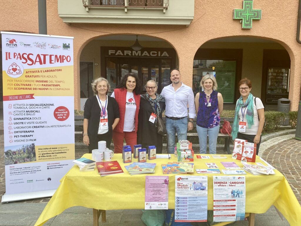 Fotografia dello stand con i volontari di AIMA Reggio Emilia per la campagna #insiemesipuò del Mese Mondiale Alzheimer 2023 ad Albinea