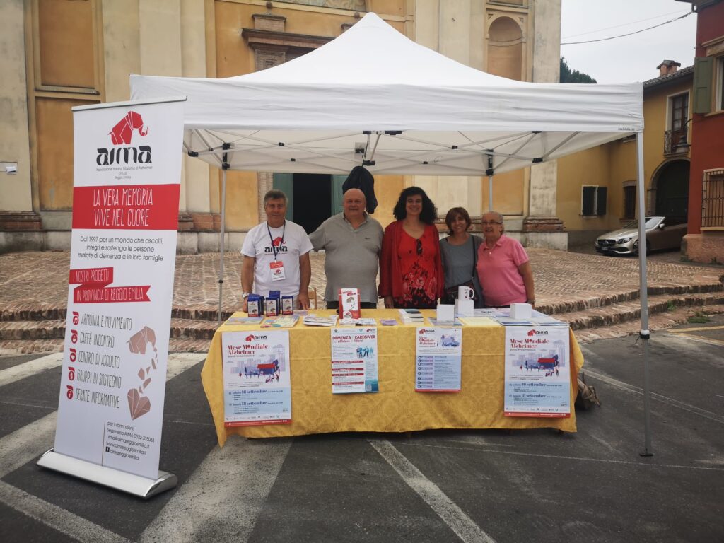 Fotografia dello stand con i volontari di AIMA Reggio Emilia per la campagna #insiemesipuò del Mese Mondiale Alzheimer 2023 a Montecchio Emilia