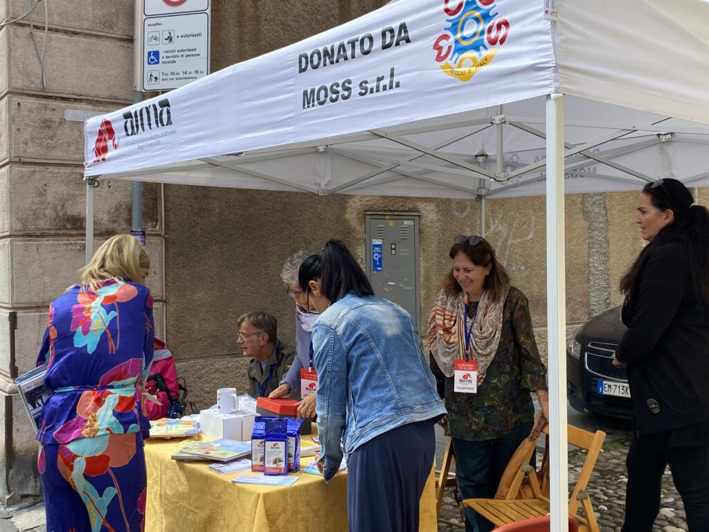 Fotografia dello stand con i volontari di AIMA Reggio Emilia per la campagna #insiemesipuò del Mese Mondiale Alzheimer 2023 a Guastalla