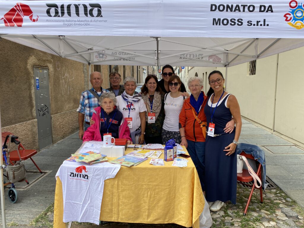 Fotografia dello stand con i volontari di AIMA Reggio Emilia per la campagna #insiemesipuò del Mese Mondiale Alzheimer 2023 a Guastalla