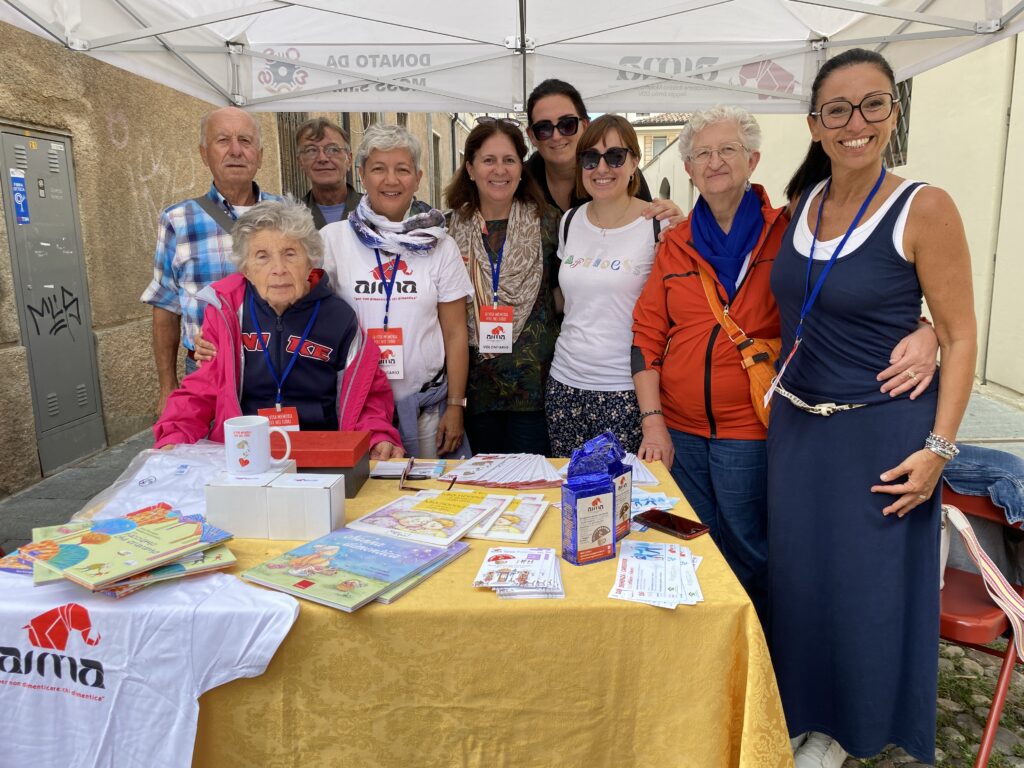 Fotografia dello stand con i volontari di AIMA Reggio Emilia per la campagna #insiemesipuò del Mese Mondiale Alzheimer 2023 a Guastalla