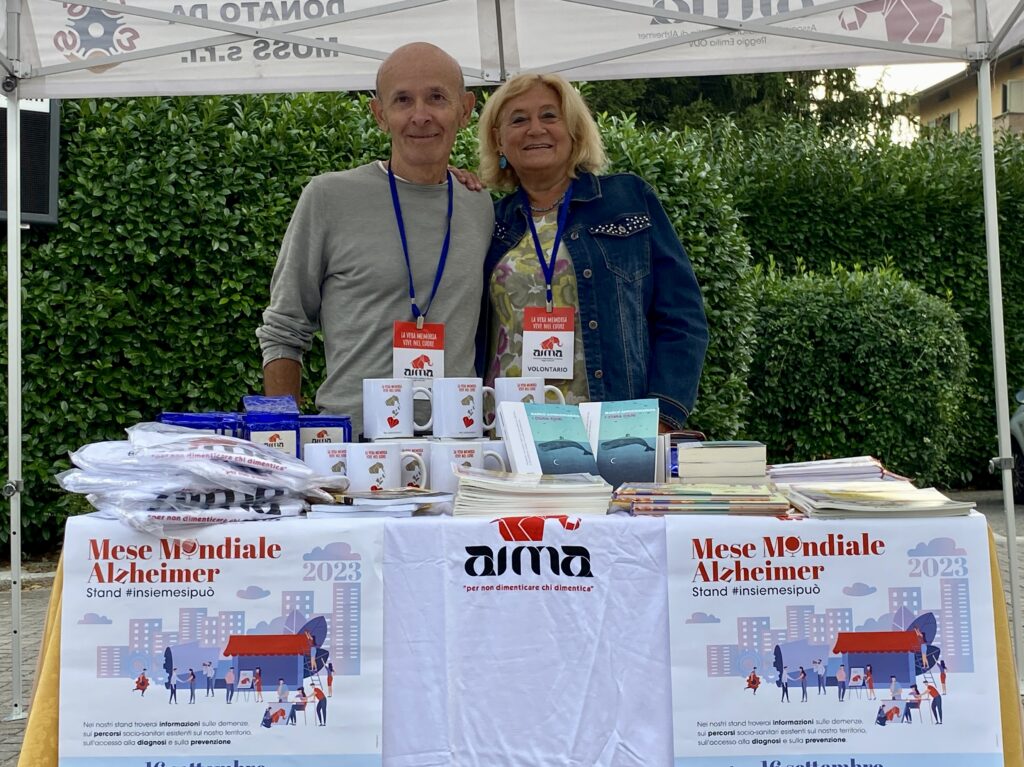 Fotografia dello stand con i volontari di AIMA Reggio Emilia per la campagna #insiemesipuò del Mese Mondiale Alzheimer 2023 in piazza Gramsci a Castelnovo ne' Monti