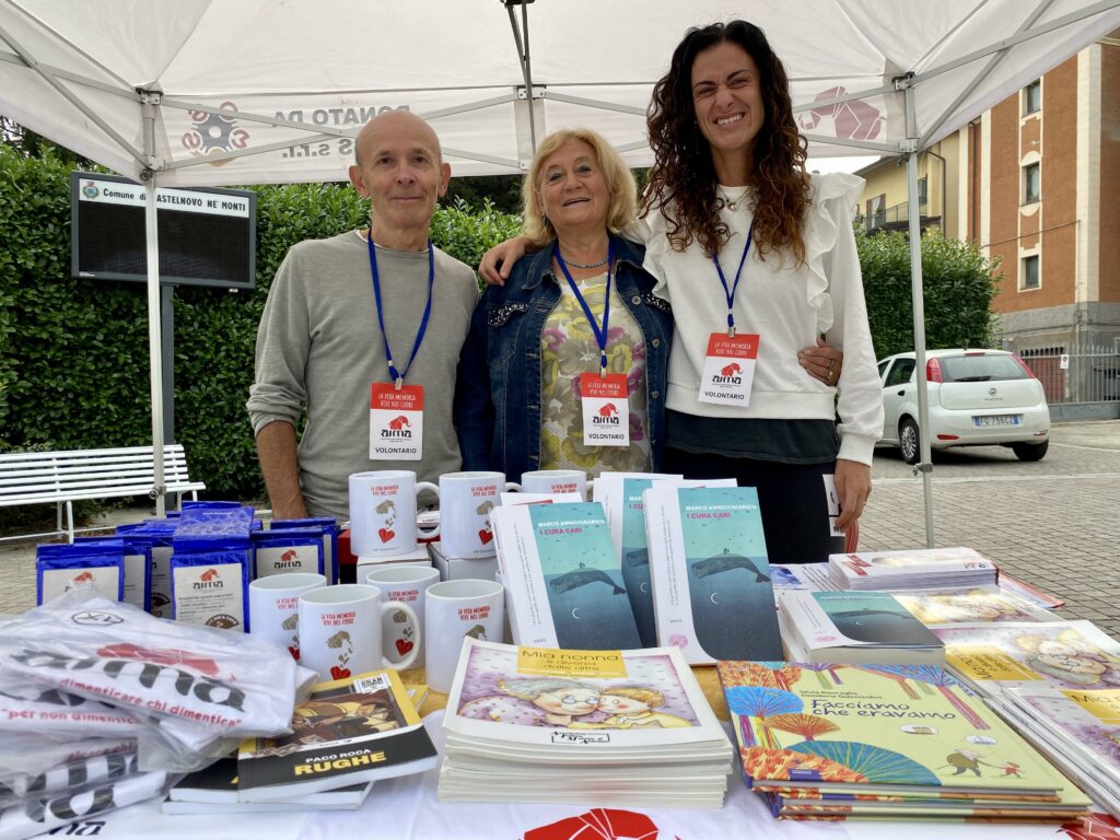 Fotografia dello stand con i volontari di AIMA Reggio Emilia per la campagna #insiemesipuò del Mese Mondiale Alzheimer 2023 in piazza Gramsci a Castelnovo ne' Monti