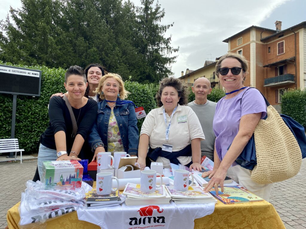 Fotografia dello stand con i volontari di AIMA Reggio Emilia per la campagna #insiemesipuò del Mese Mondiale Alzheimer 2023 in piazza Gramsci a Castelnovo ne' Monti