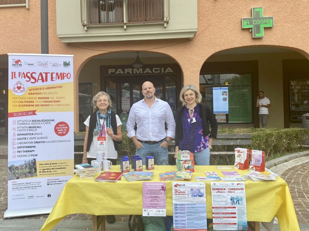 Fotografia dello stand con i volontari di AIMA Reggio Emilia per la campagna #insiemesipuò del Mese Mondiale Alzheimer 2023 ad Albinea