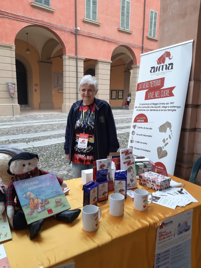 Fotografia dello stand con i volontari di AIMA Reggio Emilia per la campagna #insiemesipuò del Mese Mondiale Alzheimer a Correggio