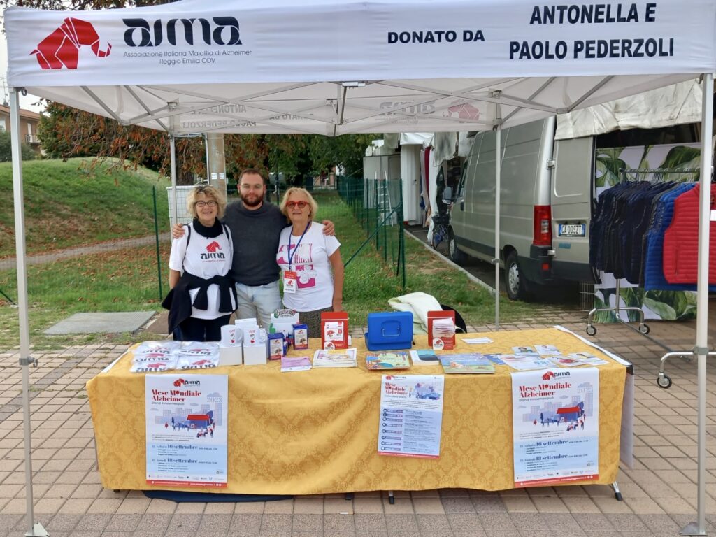 Fotografia dello stand con i volontari di AIMA Reggio Emilia per la campagna #insiemesipuò del Mese Mondiale Alzheimer 2023 a Scandiano