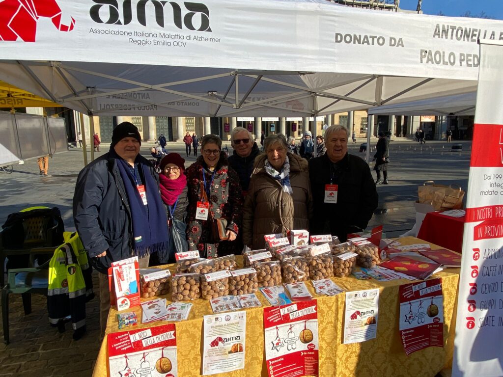 Volontari nello stand con le Noci della Memoria di AIMA Reggio Emilia in piazza Martiri nel giorno della Festa di San Prospero, 24 novembre 2023