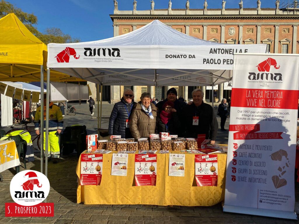 Volontari nello stand con le Noci della Memoria di AIMA Reggio Emilia in piazza Martiri nel giorno della Festa di San Prospero, 24 novembre 2023