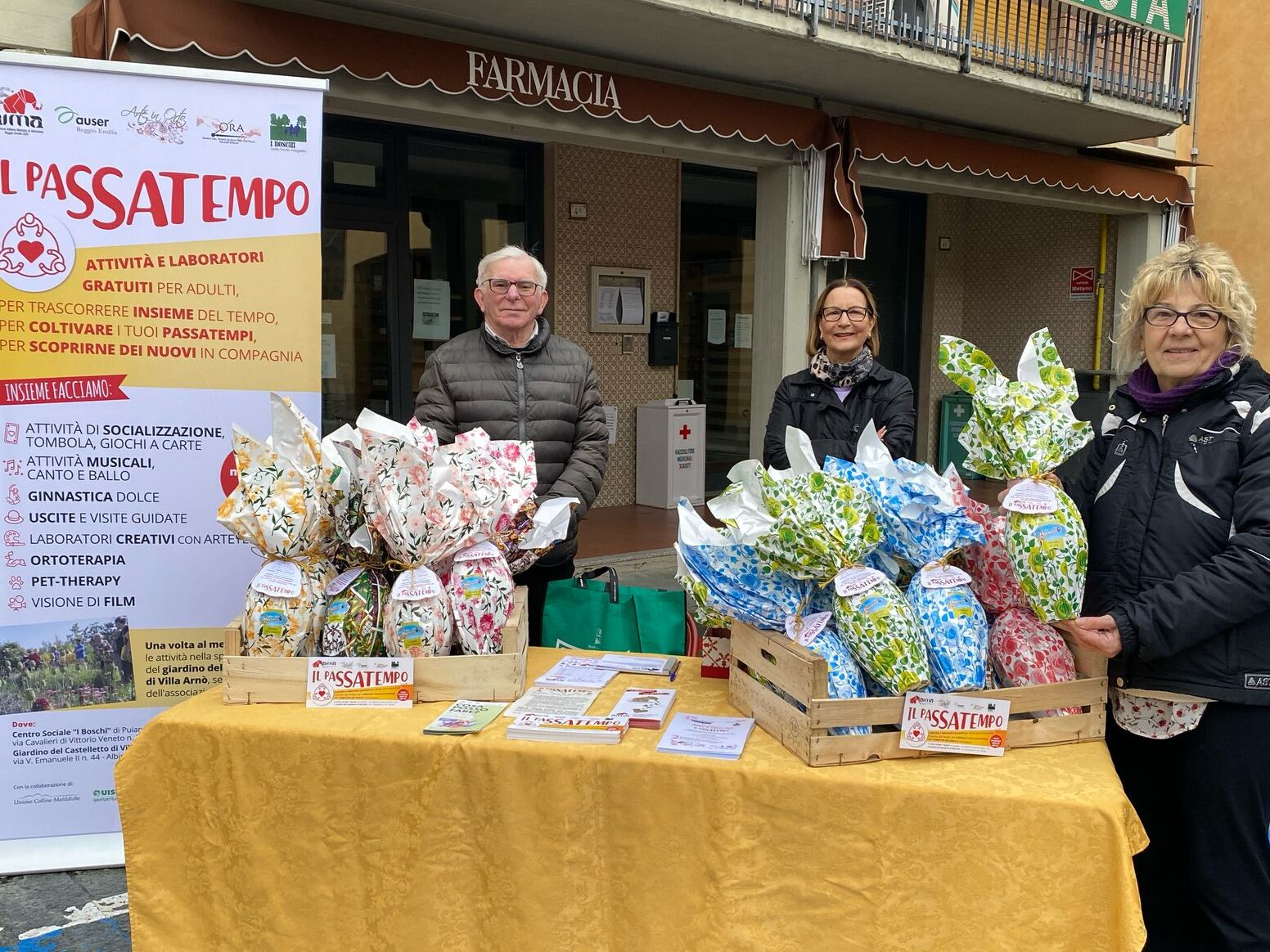 Banchetto in piazza con le Uova di Pasqua di cioccolata solidali per il progetto Il Passatempo | volontari delle associazioni partner di progetto AUSER, Banca del Tempo di Quattro Castella e Centro Sociale di Boschi di Puianello.